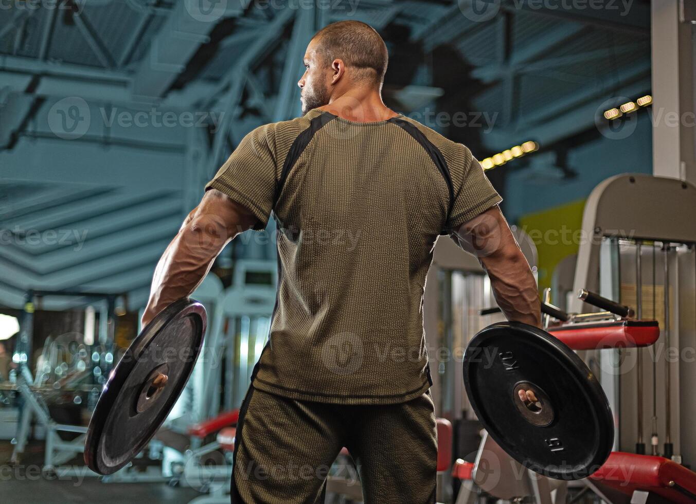 Male athlete lifting weights in a gym during an intense training session for strength building and fitness improvement photo