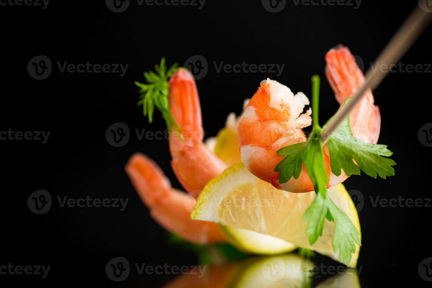 Boiled seafood shrimps with lemon isolated on black background photo