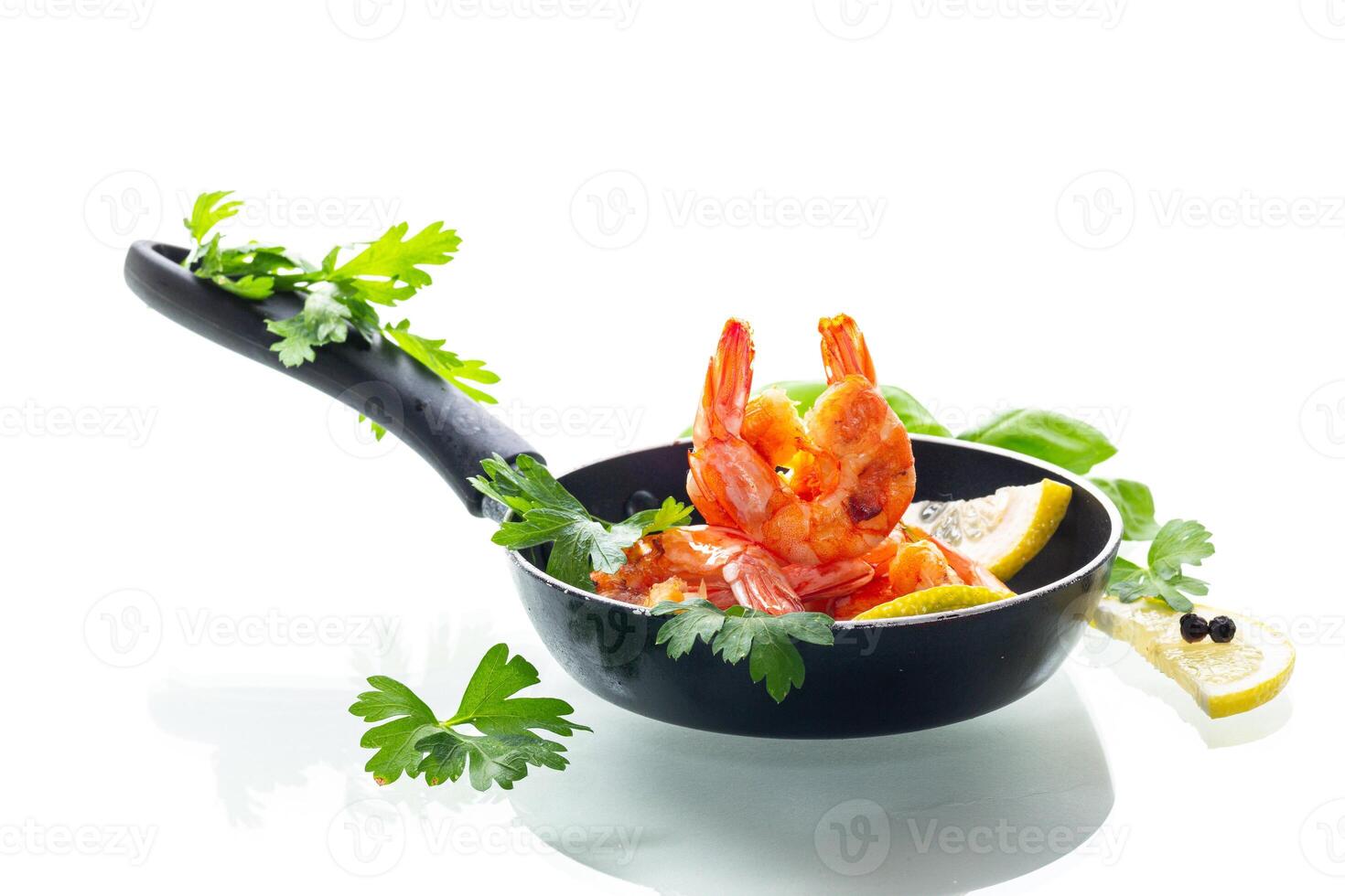 Hot shrimps with citrus slices and spices in a frying pan isolated on white photo