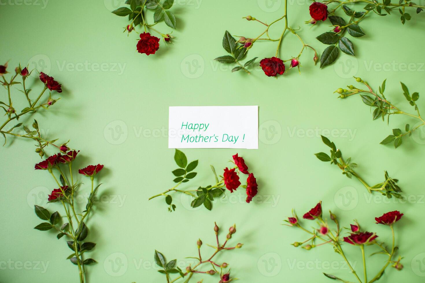 Arrangement of small red roses isolated on green photo