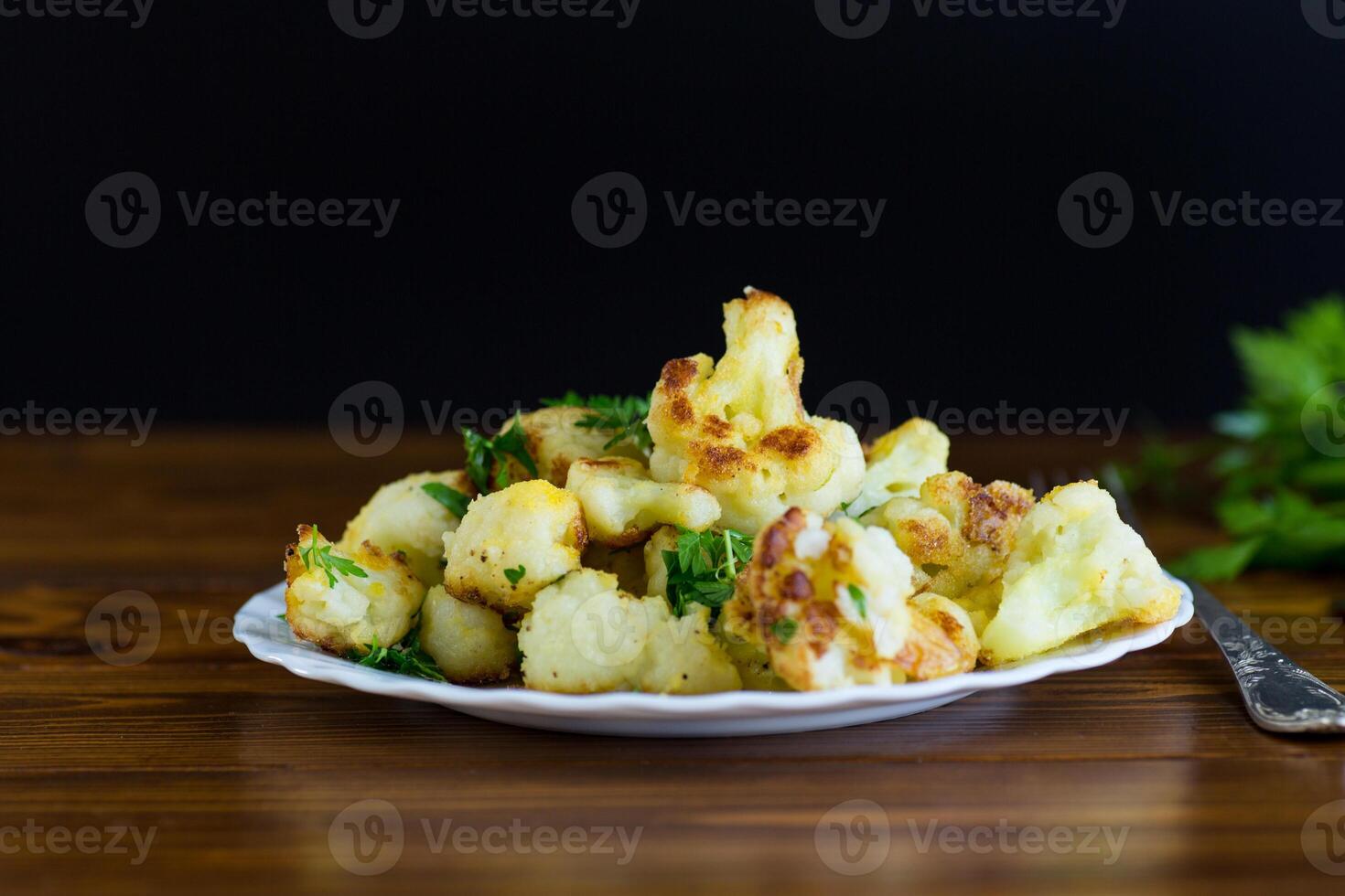 Vegetable dish of fried cabbage with aromatic spices, black background photo