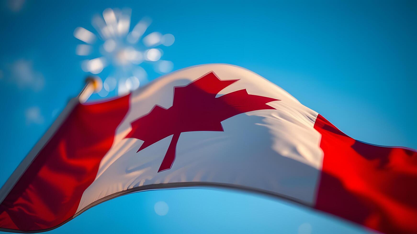 A dynamic Canadian flag waves against a bright blue sky, evoking a sense of patriotism and photo