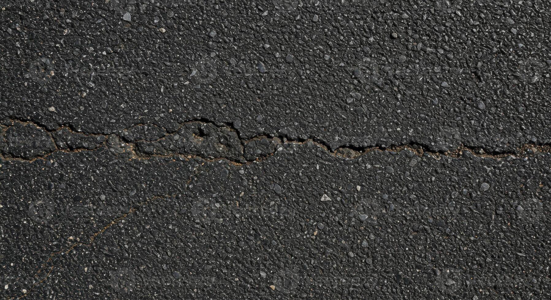 Crack in asphalt road surface photo