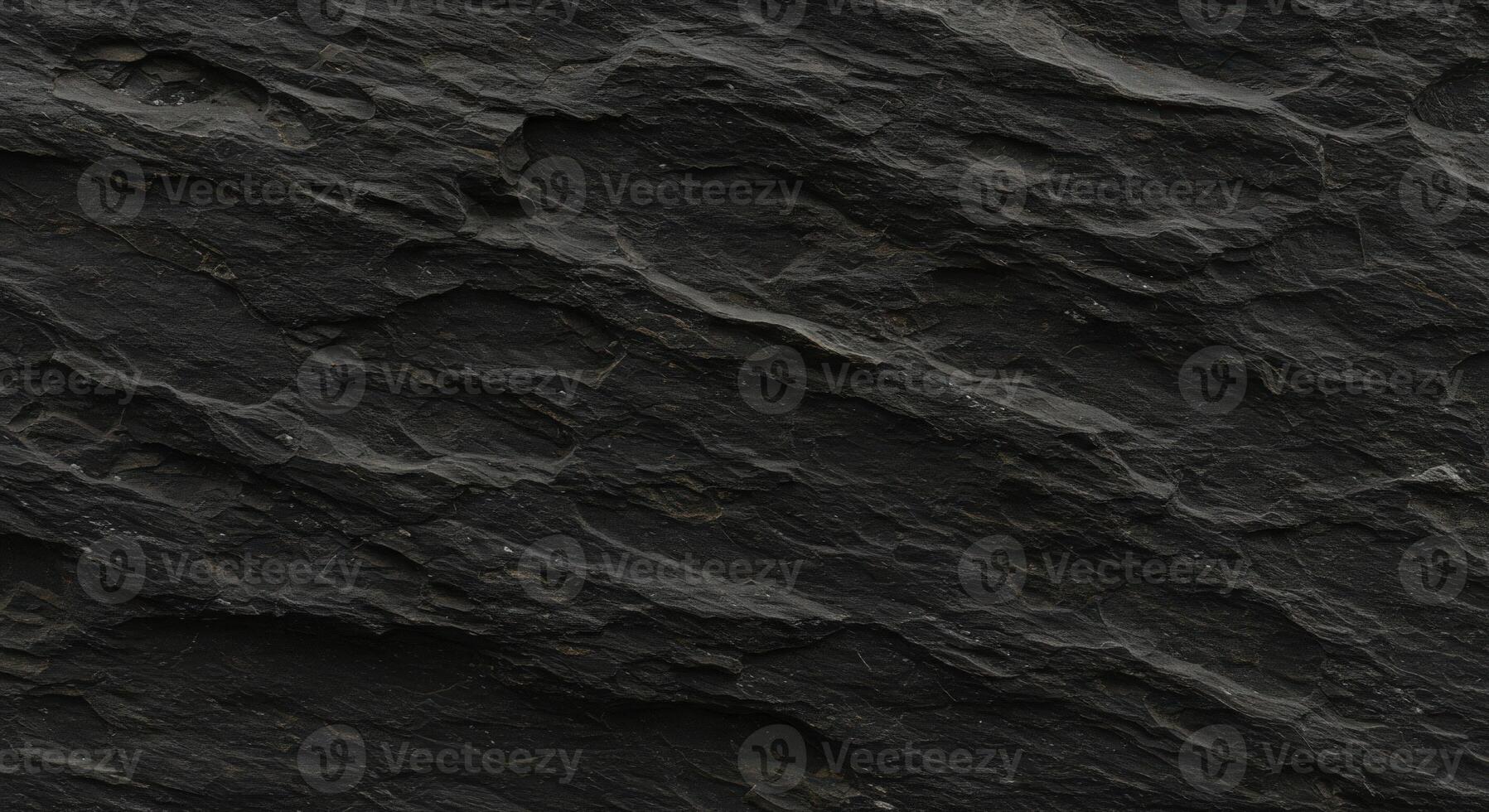 A black rock texture with some small cracks photo