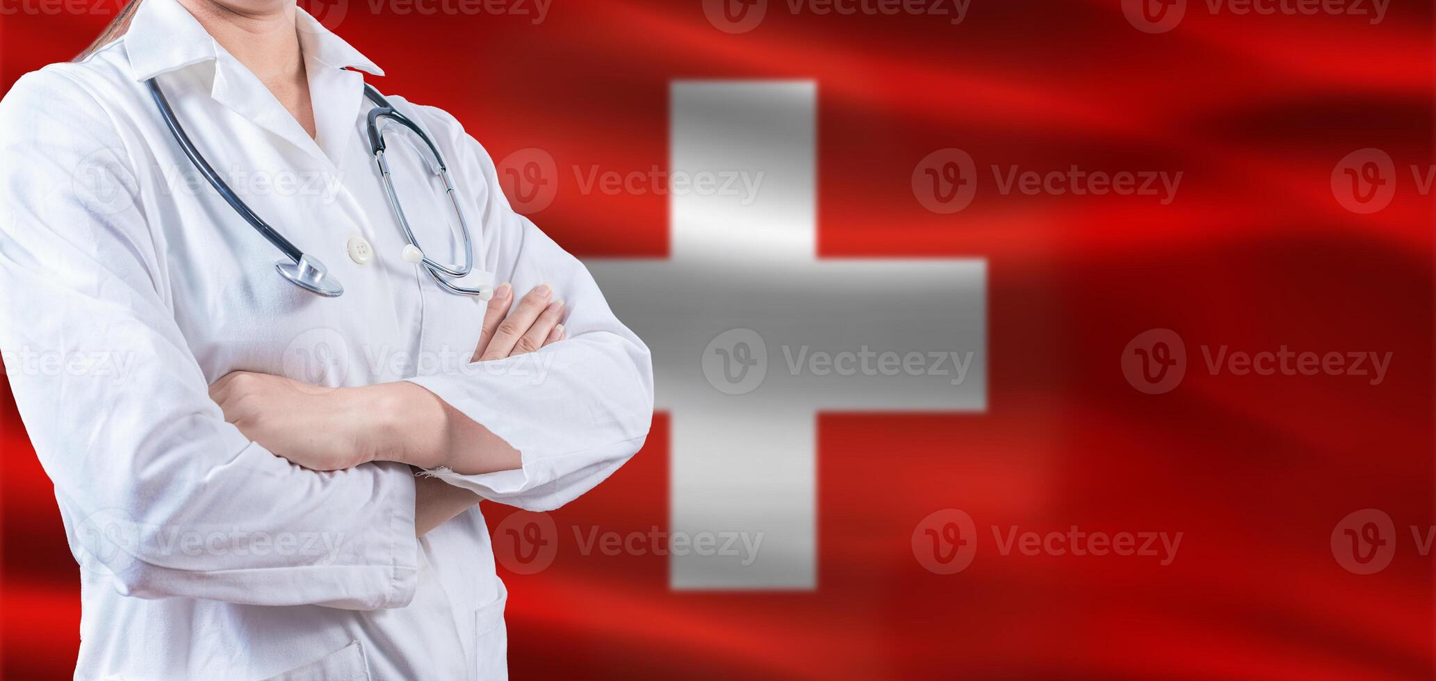 Doctor with crossed arms on Switzerland flag. Switzerland health and care concept. Female doctor on Switzerland flag photo