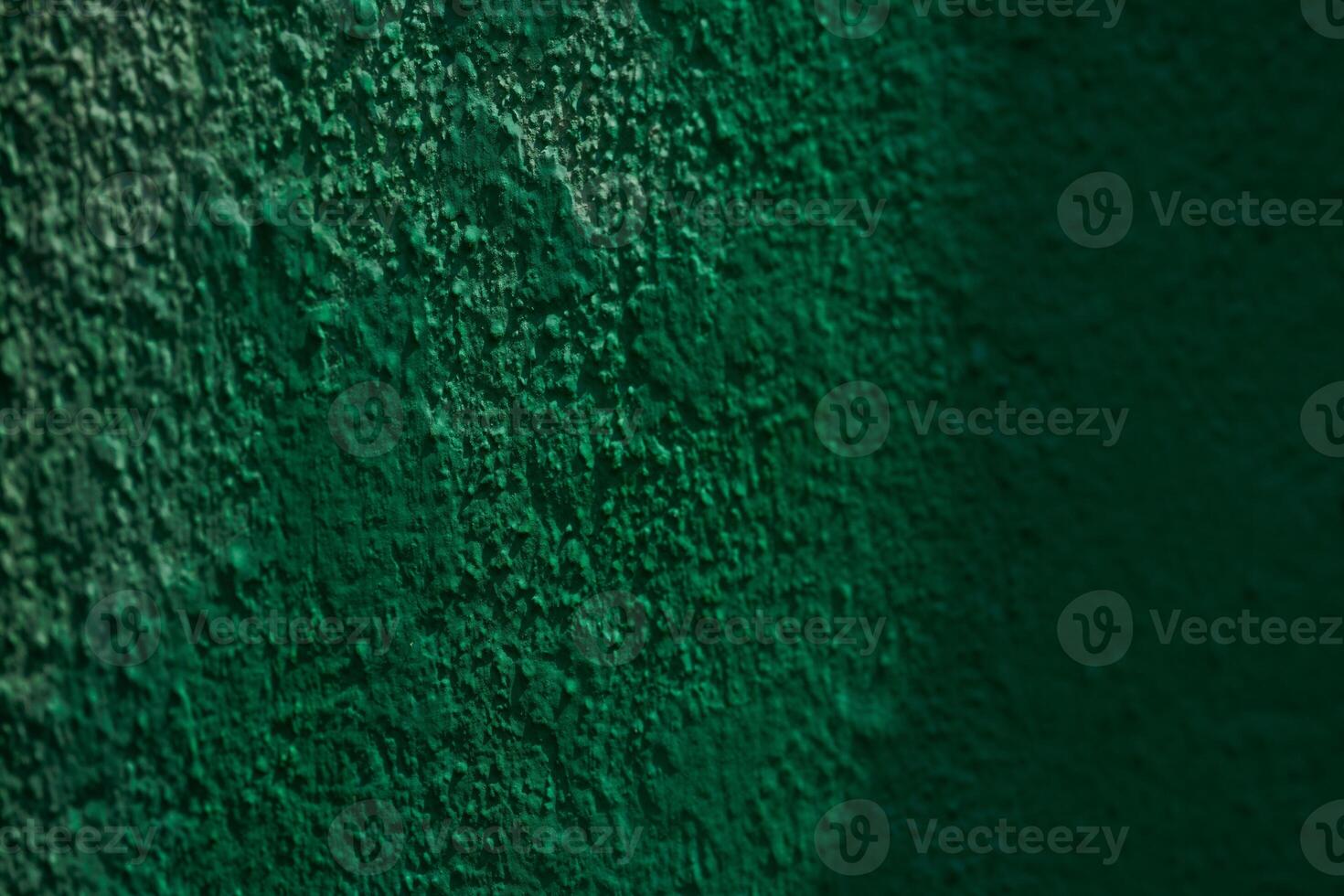 Close-up of textured green wall surface with shadows photo