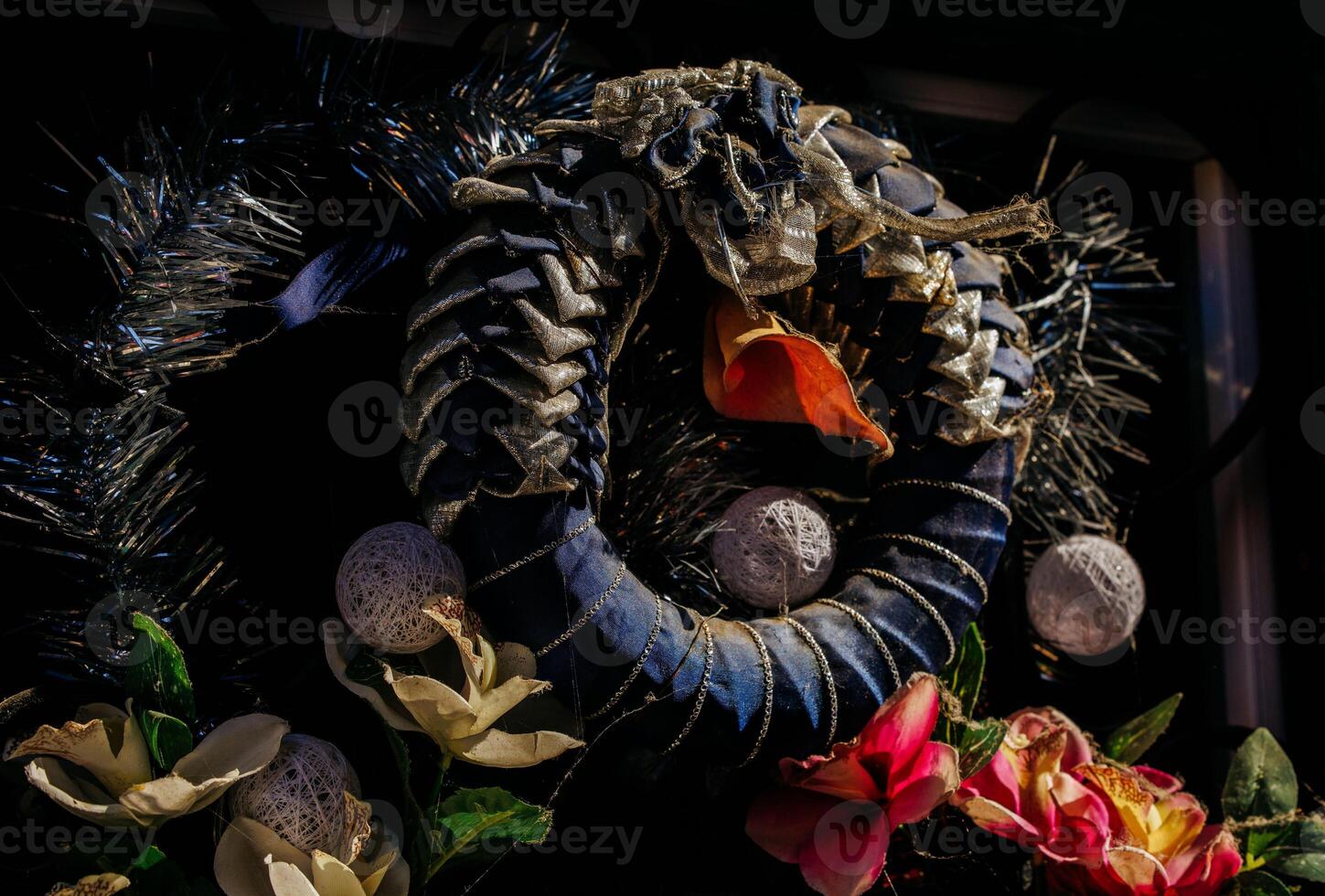 Festive holiday wreath with ornaments and flowers in sunlight photo