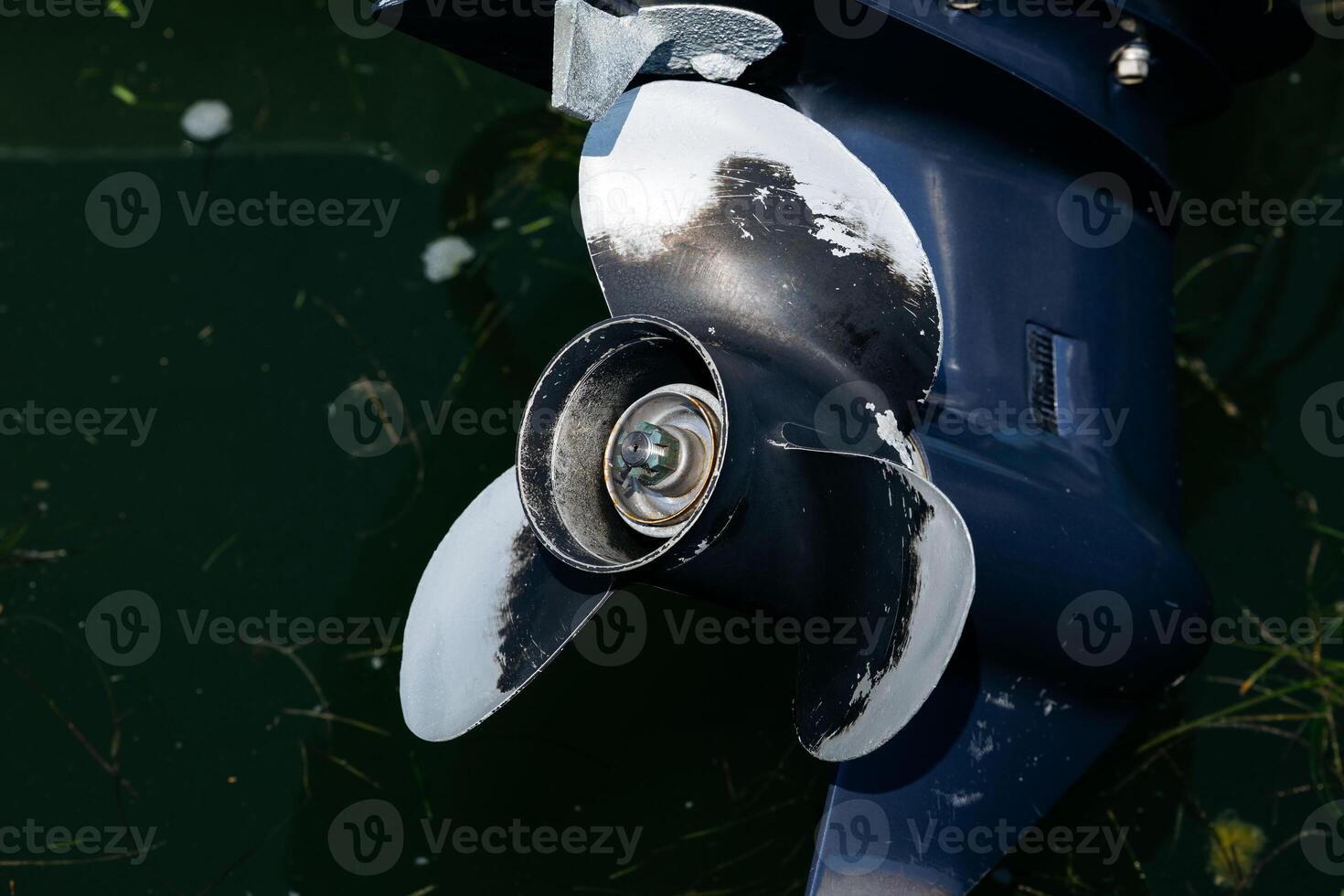Close-up of boat propeller in water with algae photo