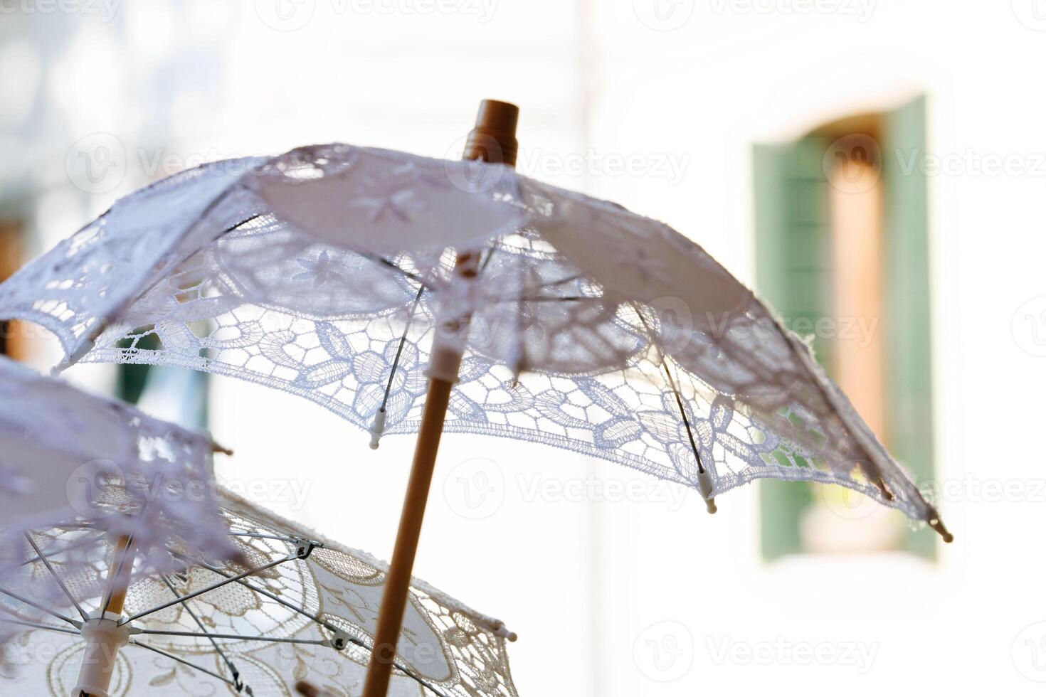 Elegant lace parasols in sunlit scene near mediterranean architecture photo