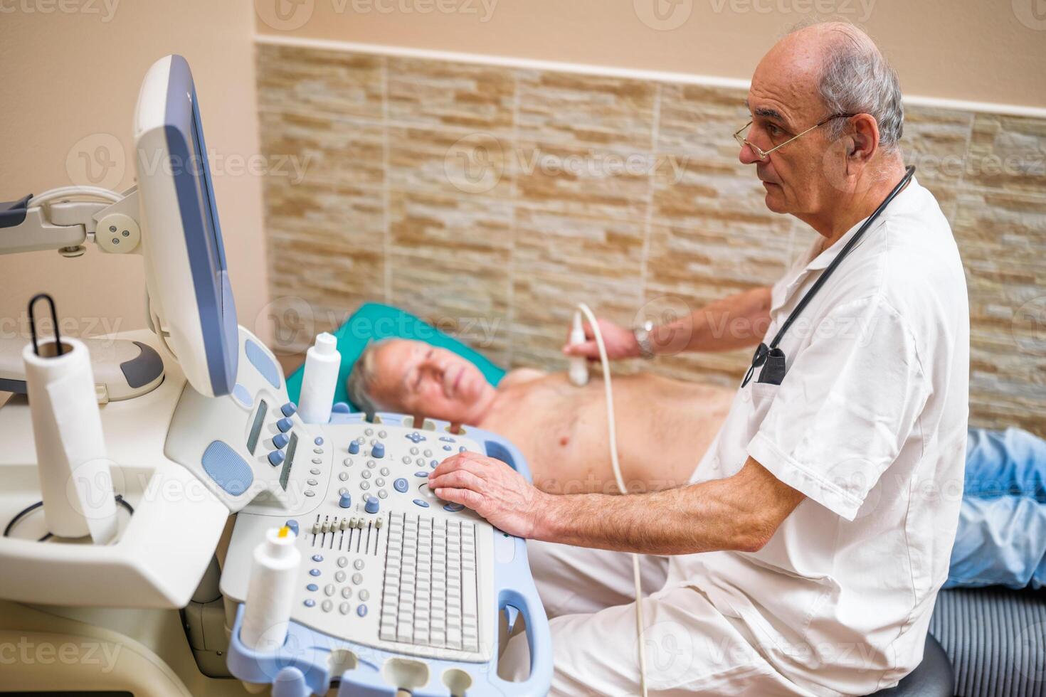 Senior man having medical exam. Elderly patient is having ultrasound examination of his heart by experienced doctor. photo