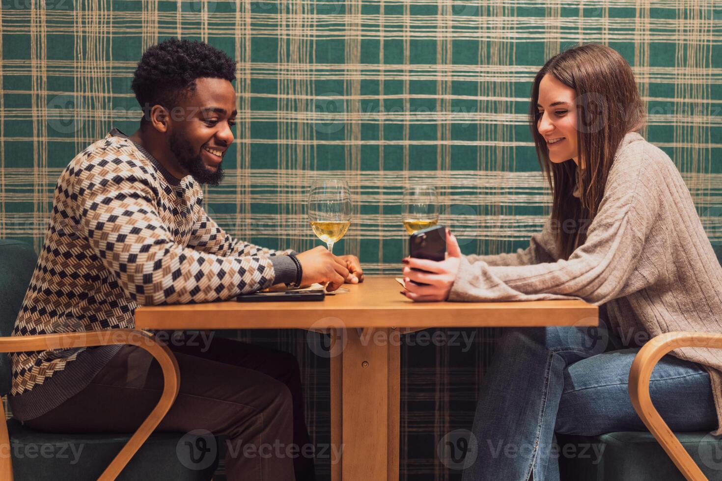 Young couple using a smartphone while eating at a restaurant, capturing memories and sharing joy during a romantic evening. photo