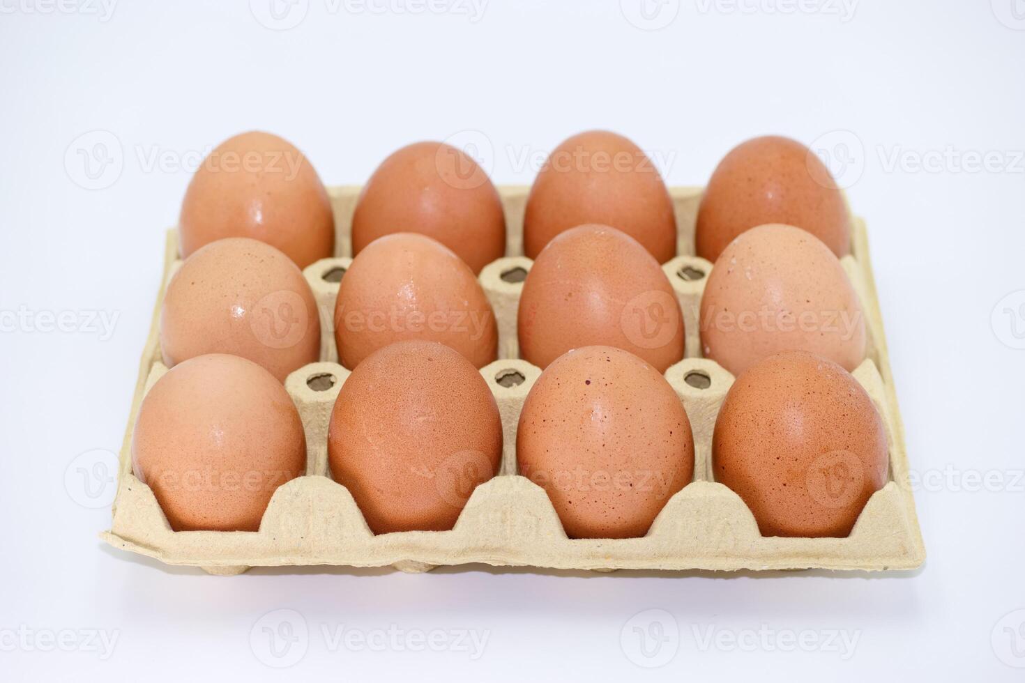 Fresh farm eggs arranged in a dozen carton ready for cooking or baking at home photo