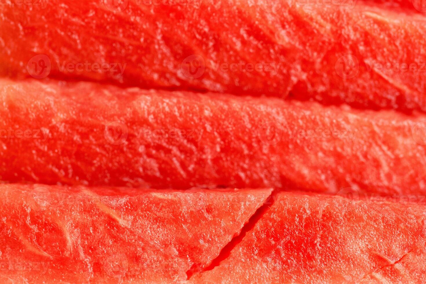 Freshly sliced watermelon showcasing vibrant red fruit and textured rind during summer season photo