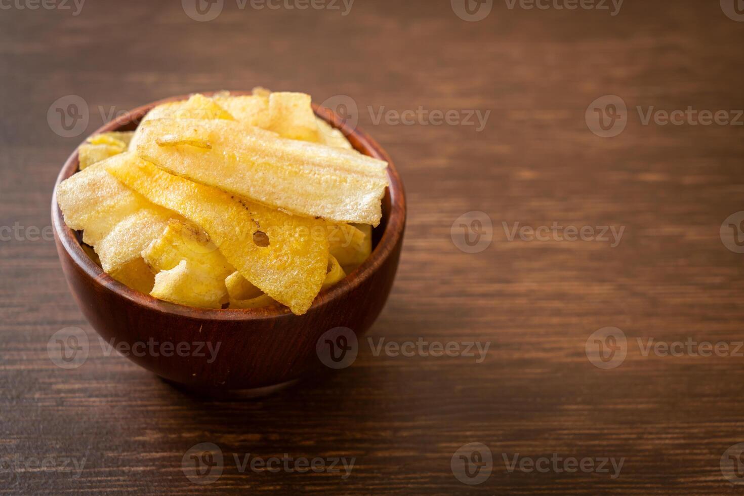 Banana Chips - fried or baked sliced banana in wooden bowl photo