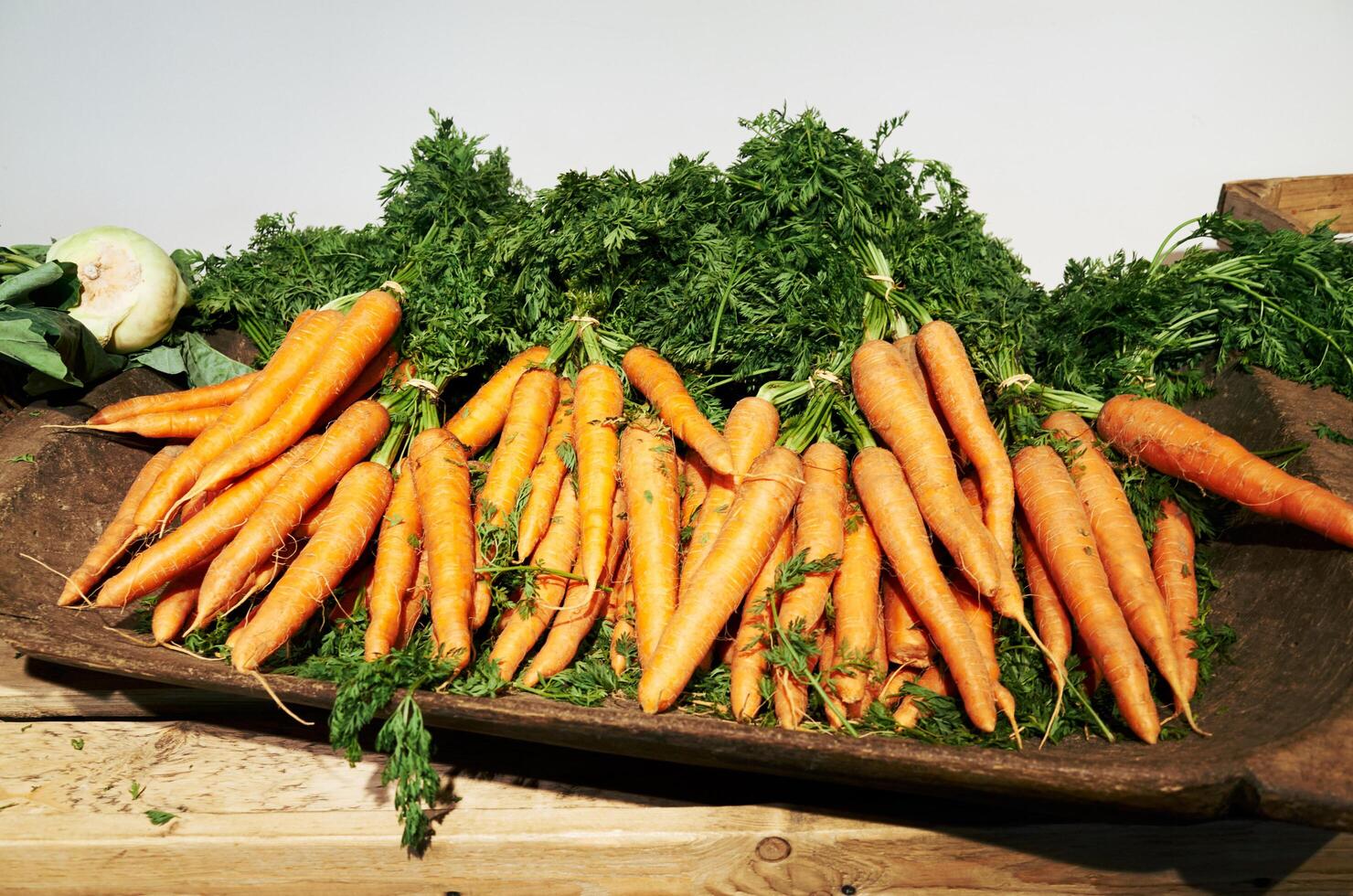 Basket full of carrots and green vegetables photo