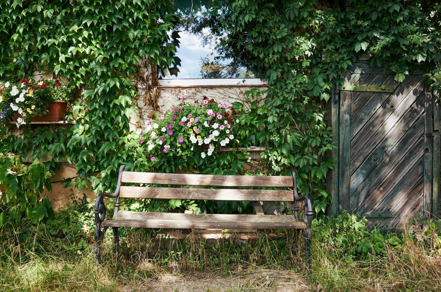 Wooden bench is sitting in front of a house with a green door photo