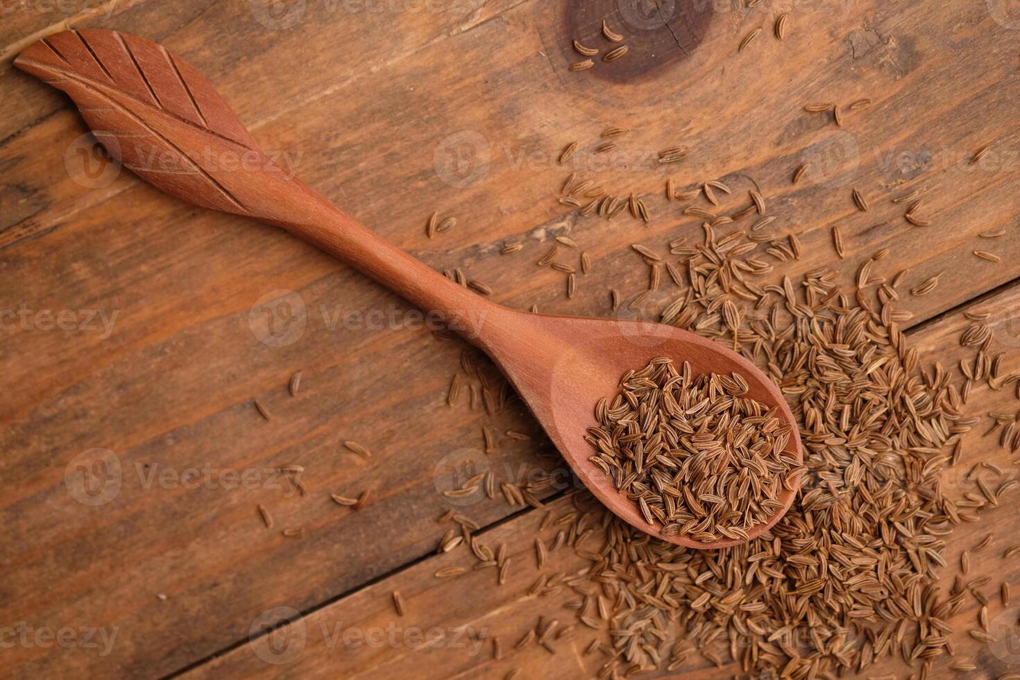Cumin is a flowering plant from the Apiaceae family that originates from the eastern Mediterranean region to eastern India. Cuminum cyminum. Cumin seed on wooden spoon photo