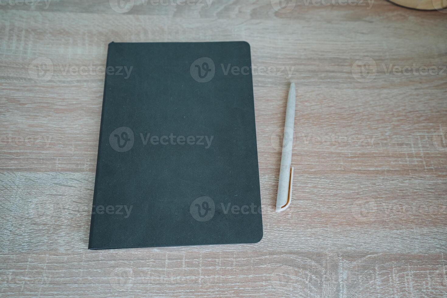 On a smooth wooden table rests a beautifully designed notebook and polished pen, creating an inviting scene perfect for jotting down notes and inspiring thoughts on a productive day photo