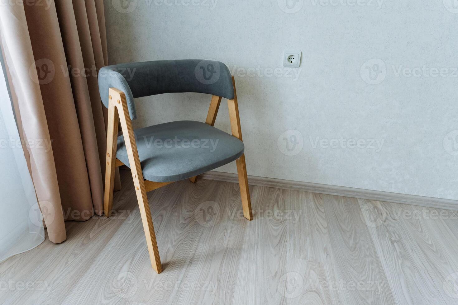 In a cozy room, warm natural light fills the space, illuminating a charming wooden chair on a polished floor by a sunny window, creating a perfect atmosphere for relaxation photo