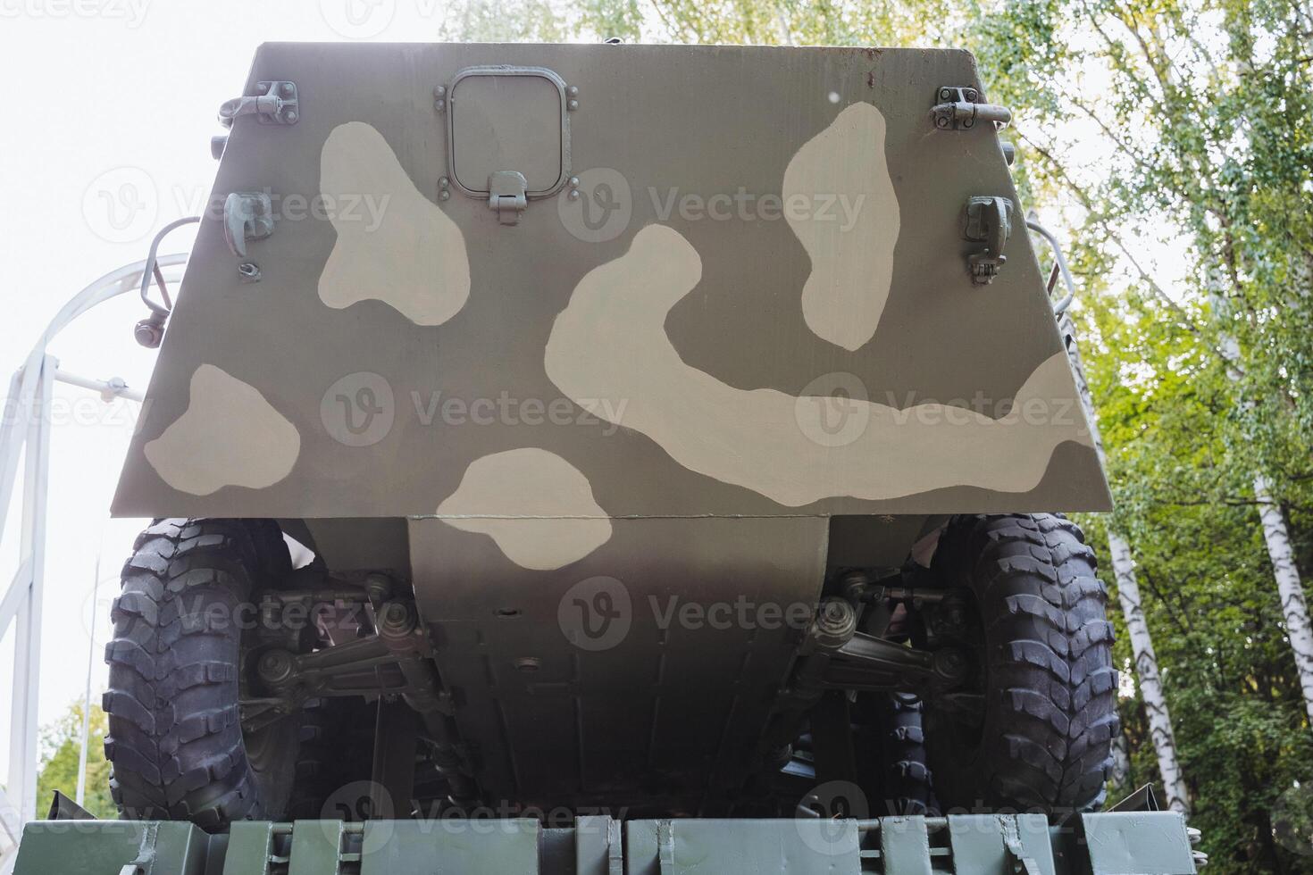 This image features the rear section of a military vehicle, which is designed with a distinct camouflage pattern, suitable for blending into various terrains and environments photo