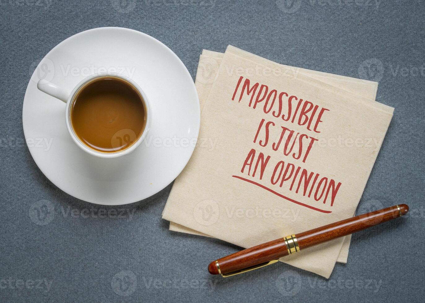 Impossible is just an opinion - inspirational writing on a napkin with coffee photo