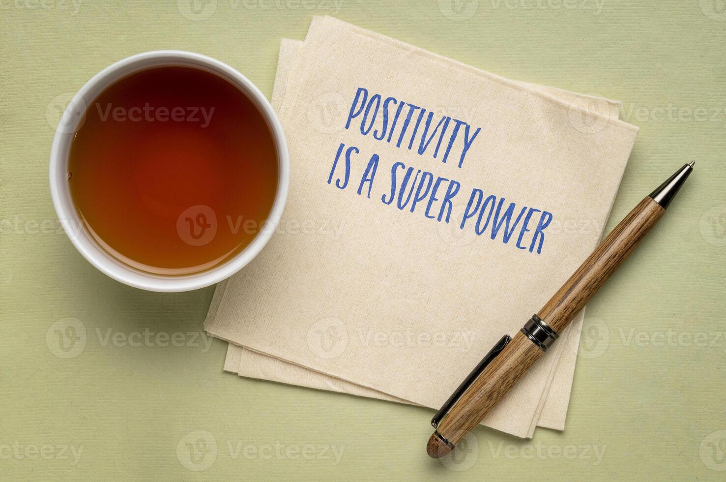 Positivity is a super power - inspiraitonal handwriting on a napkin with a cup of tea photo