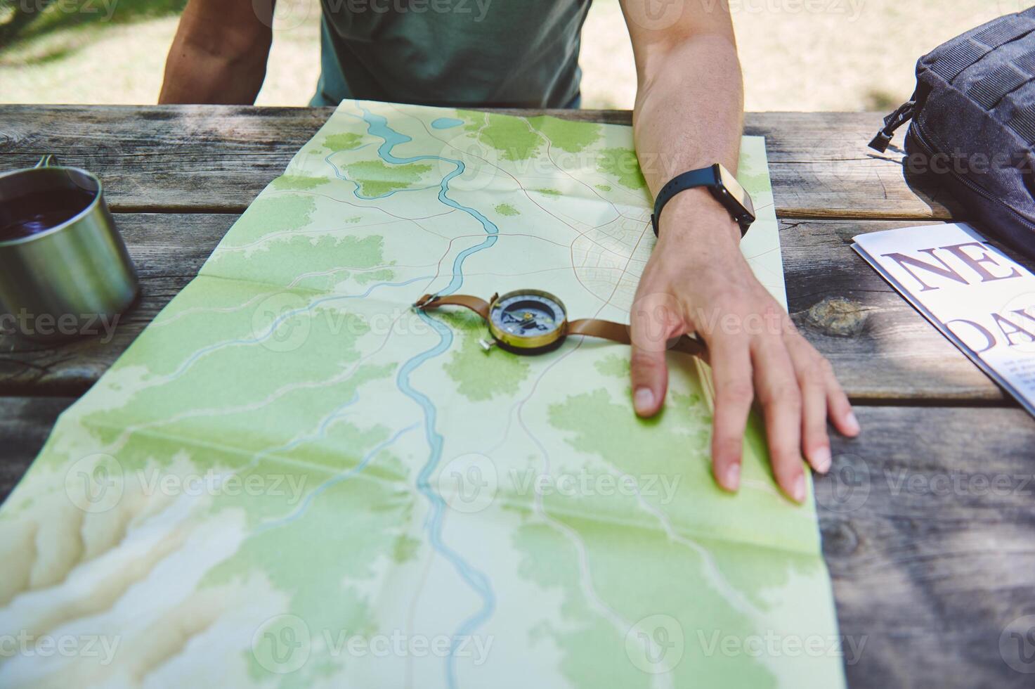 Explorer Planning Path using Map, Compass, Resting at Outdoors Table photo