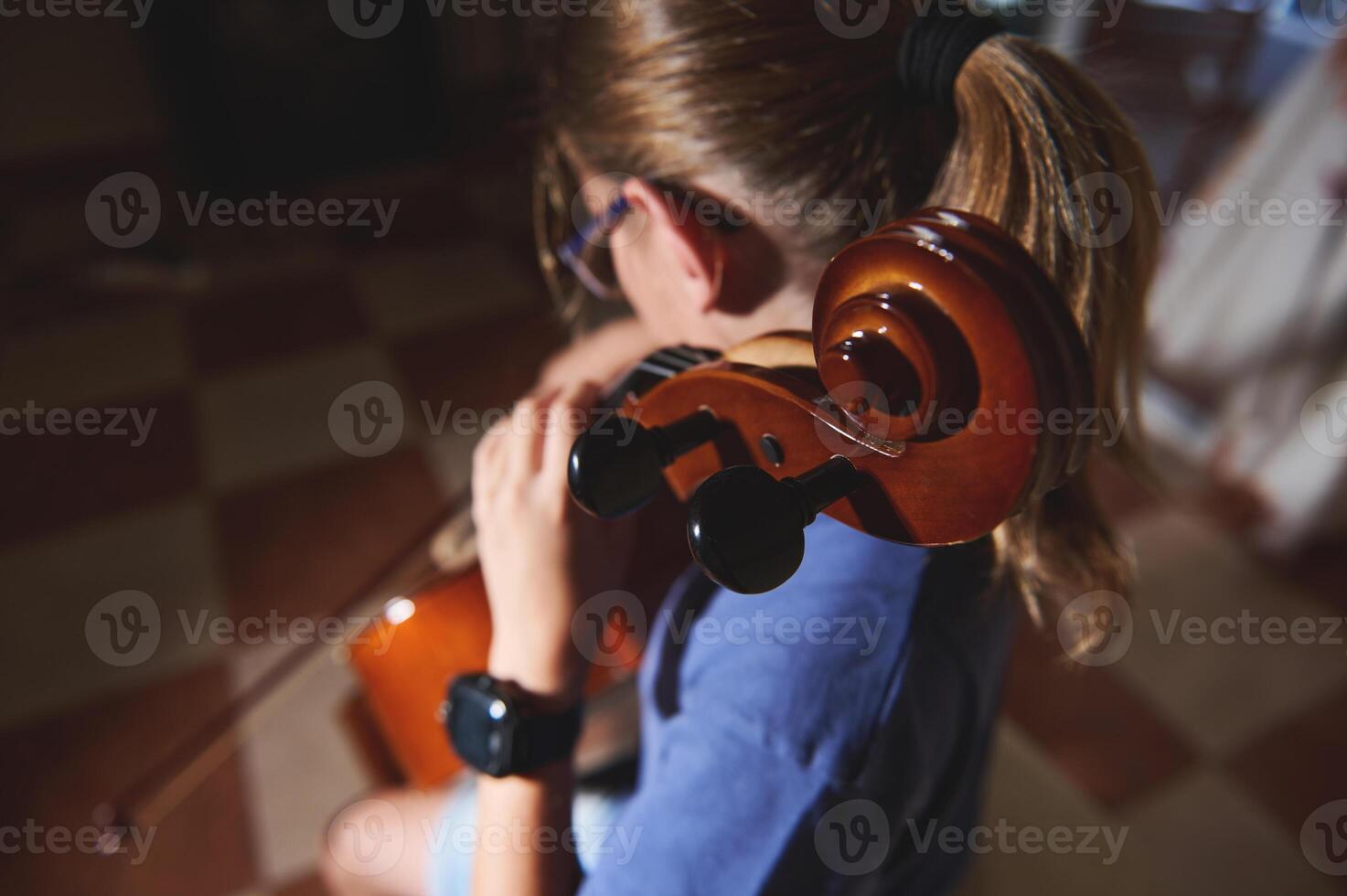Young Musician Practicing the Cello in a Harmonious and Focused Home Environment photo