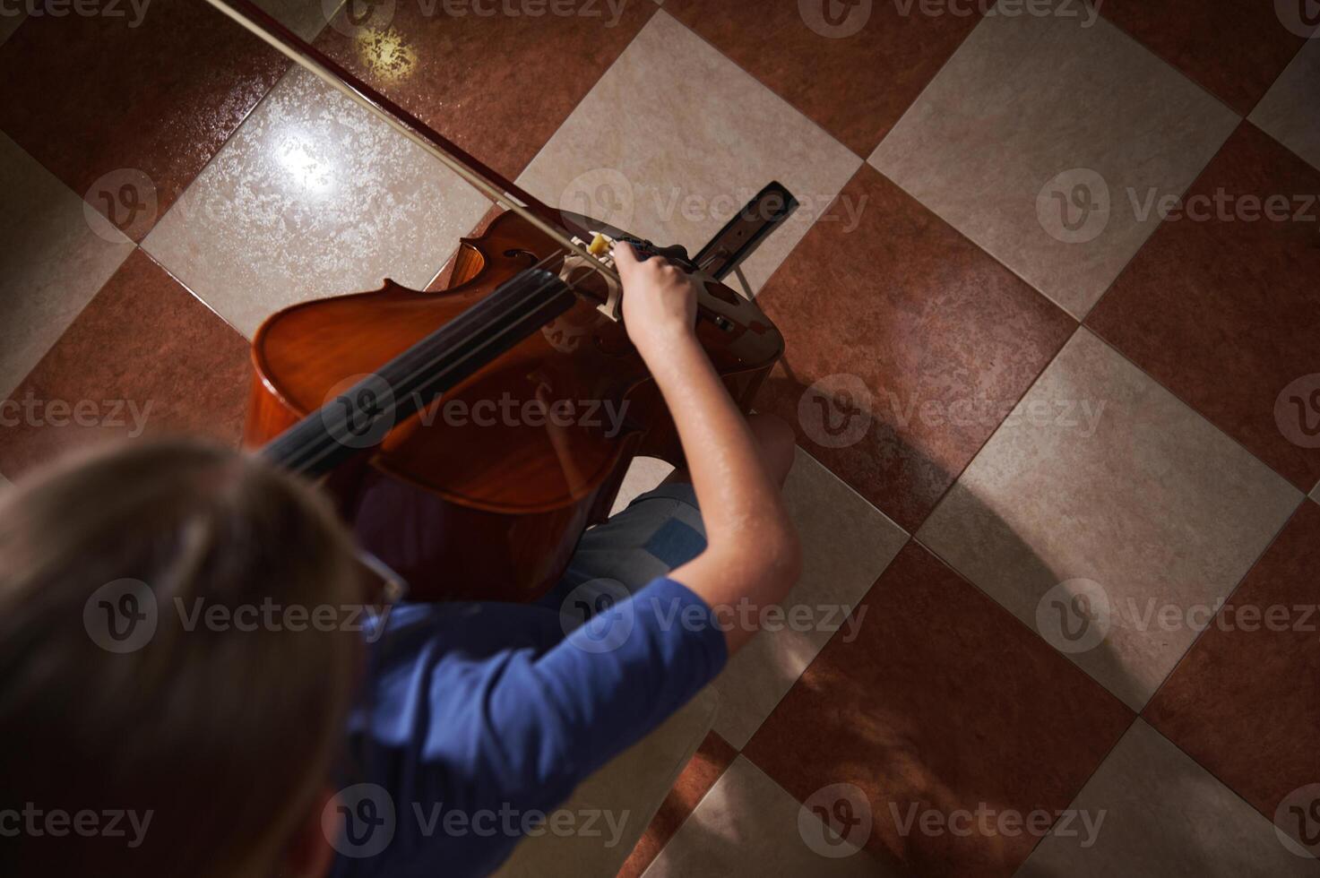 Overhead View of a Person Playing Cello on Tiled Floor photo