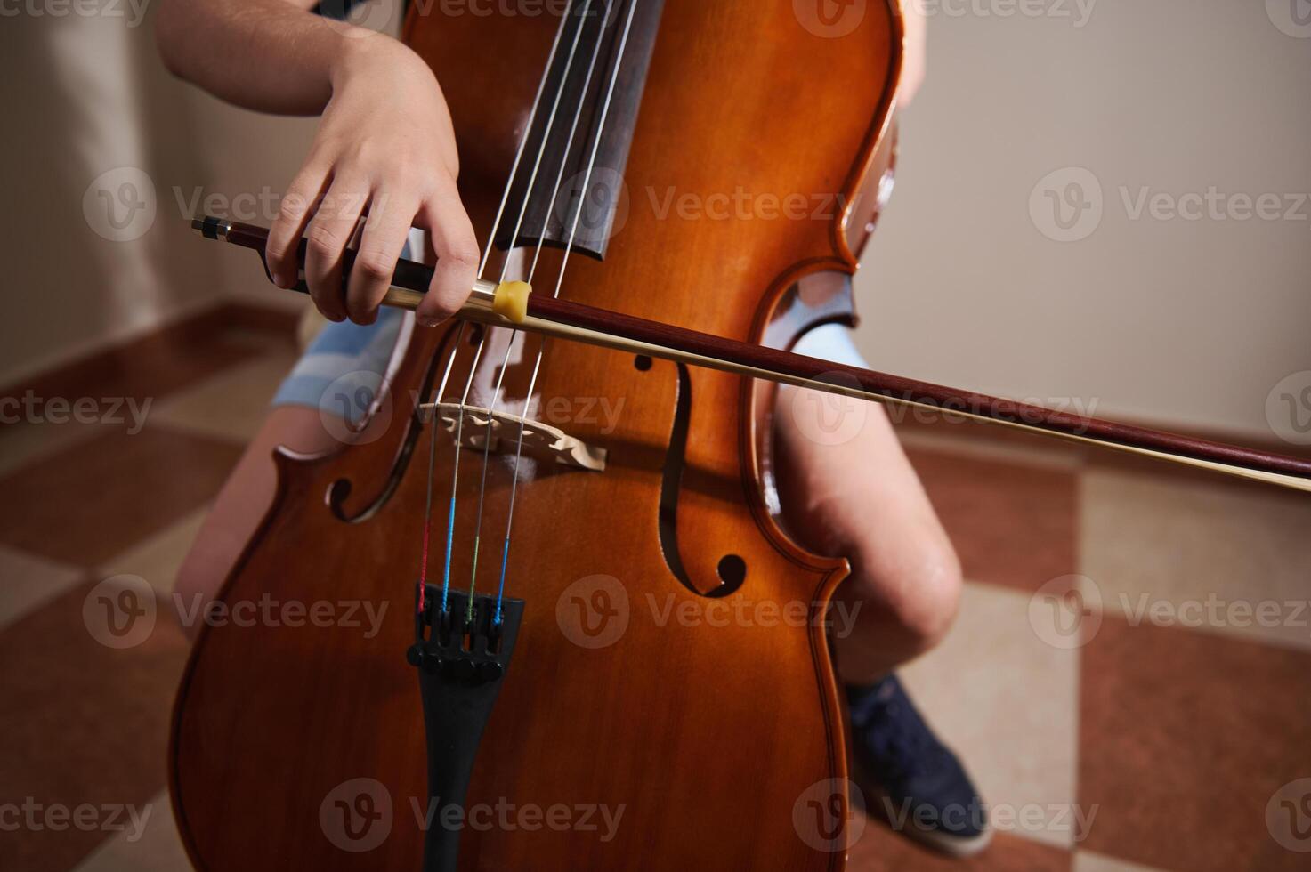 Close-Up of Student Playing a Cello in a Music Practice Setting photo