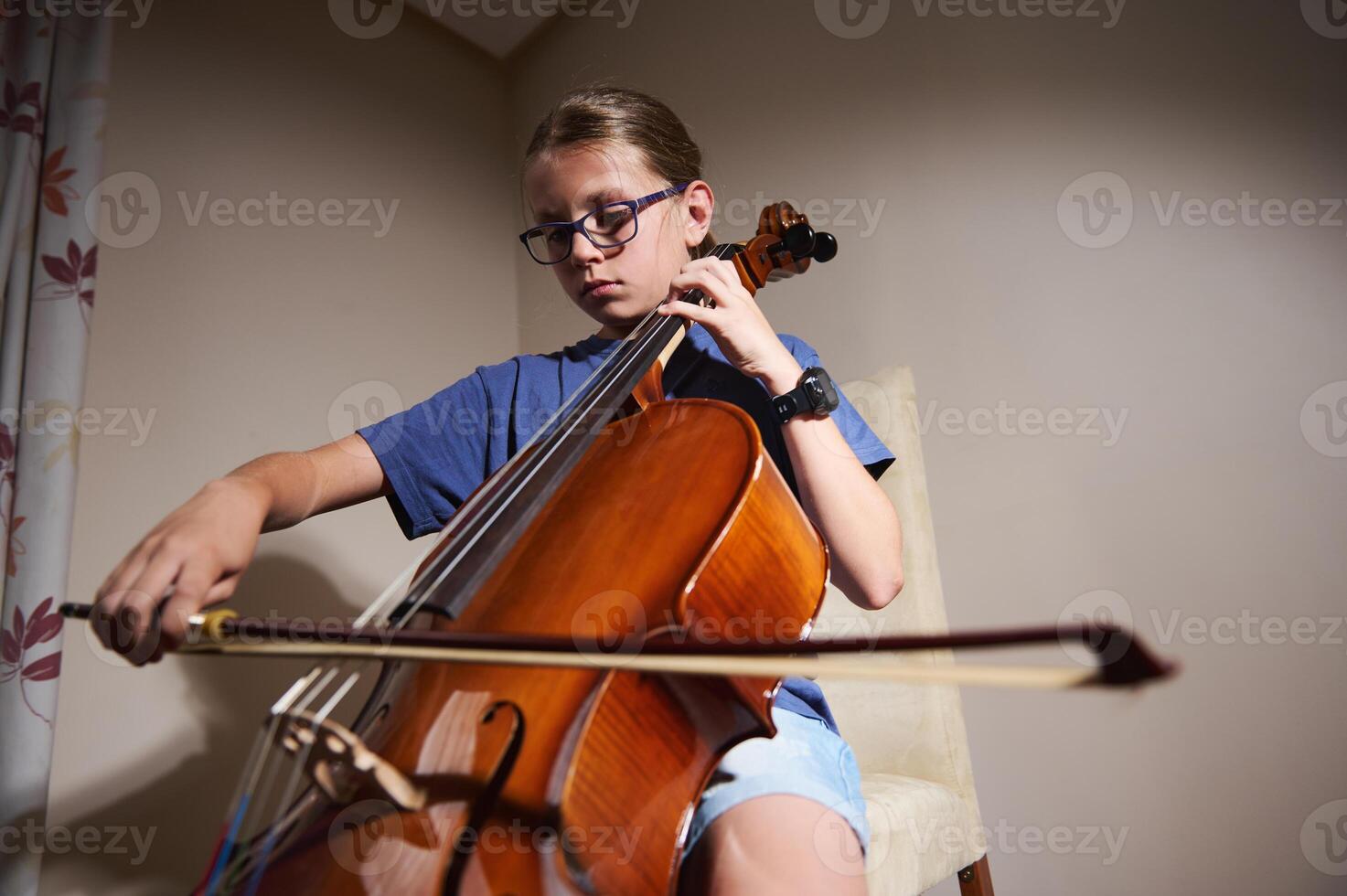 Young Musician Practicing the Cello in Warm Indoor Light photo