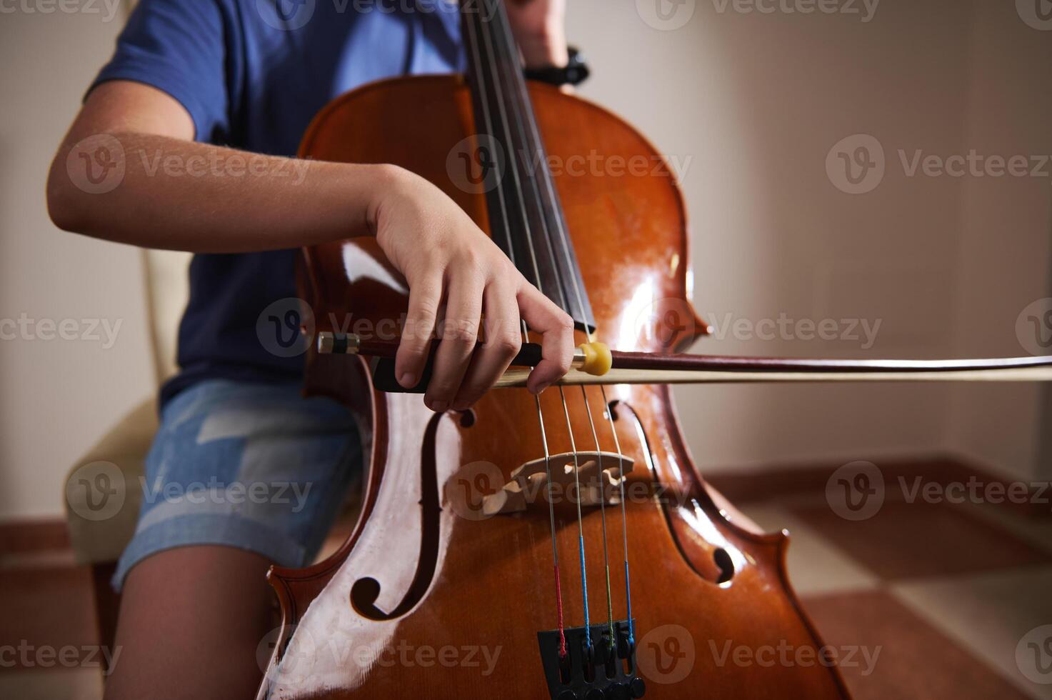 Young Musician Playing a Cello with Focus and Precision Indoors photo