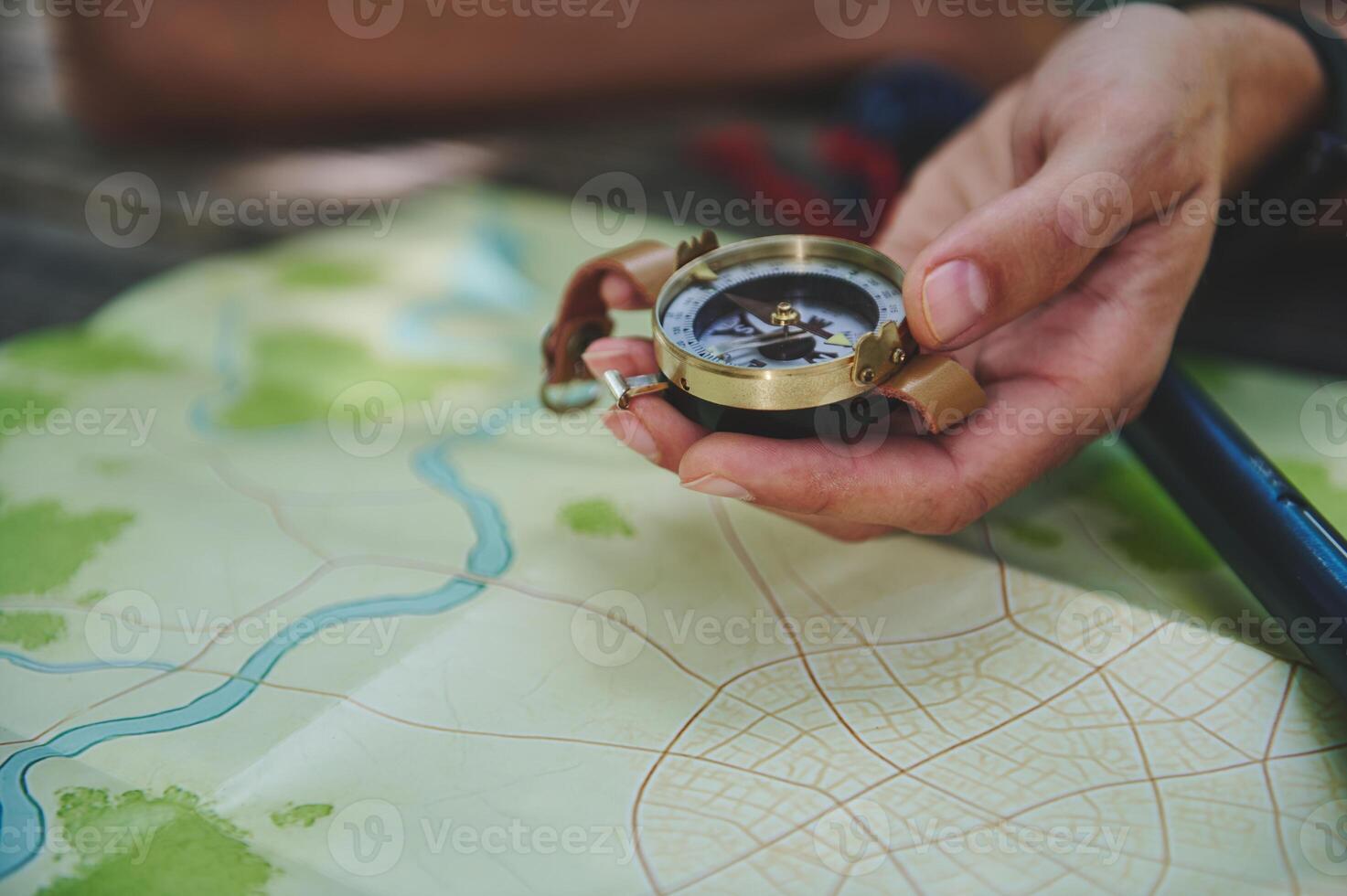 Traveler Holding a Compass Over a Map Highlights Navigation and Exploration photo