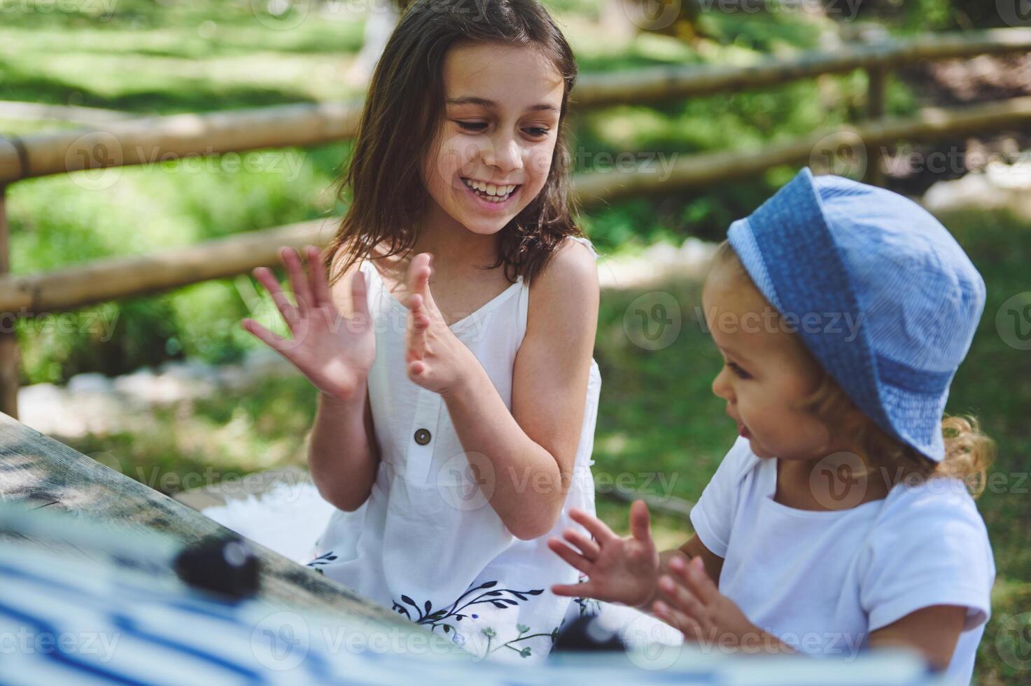 Cheerful Girls Clapping and Laughing Outdoors on a Sunny Summer Day photo