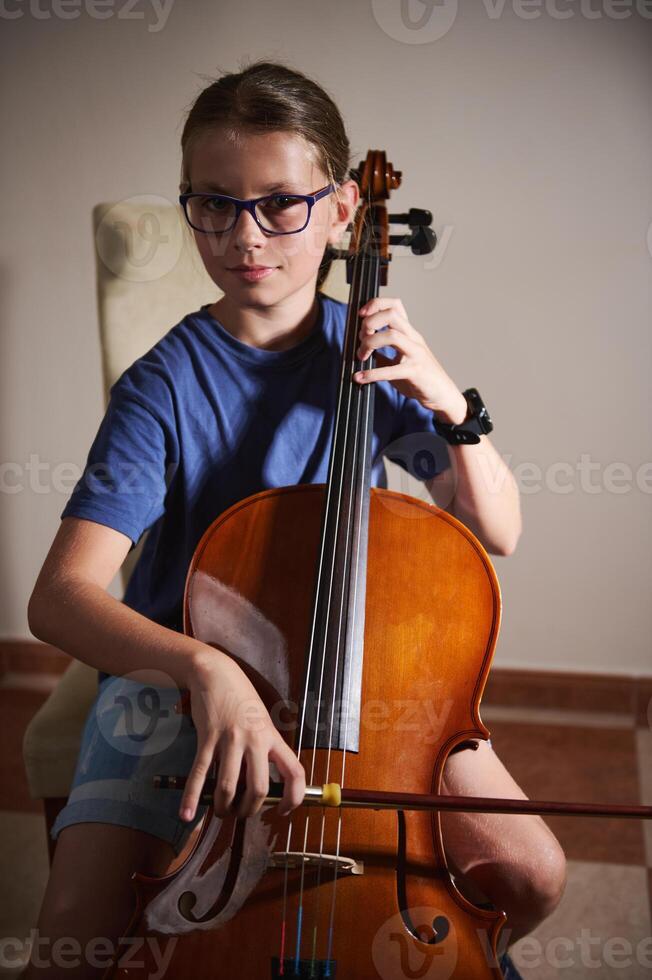 Young Cellist Playing Cello in a Home Environment with Focused Expression photo