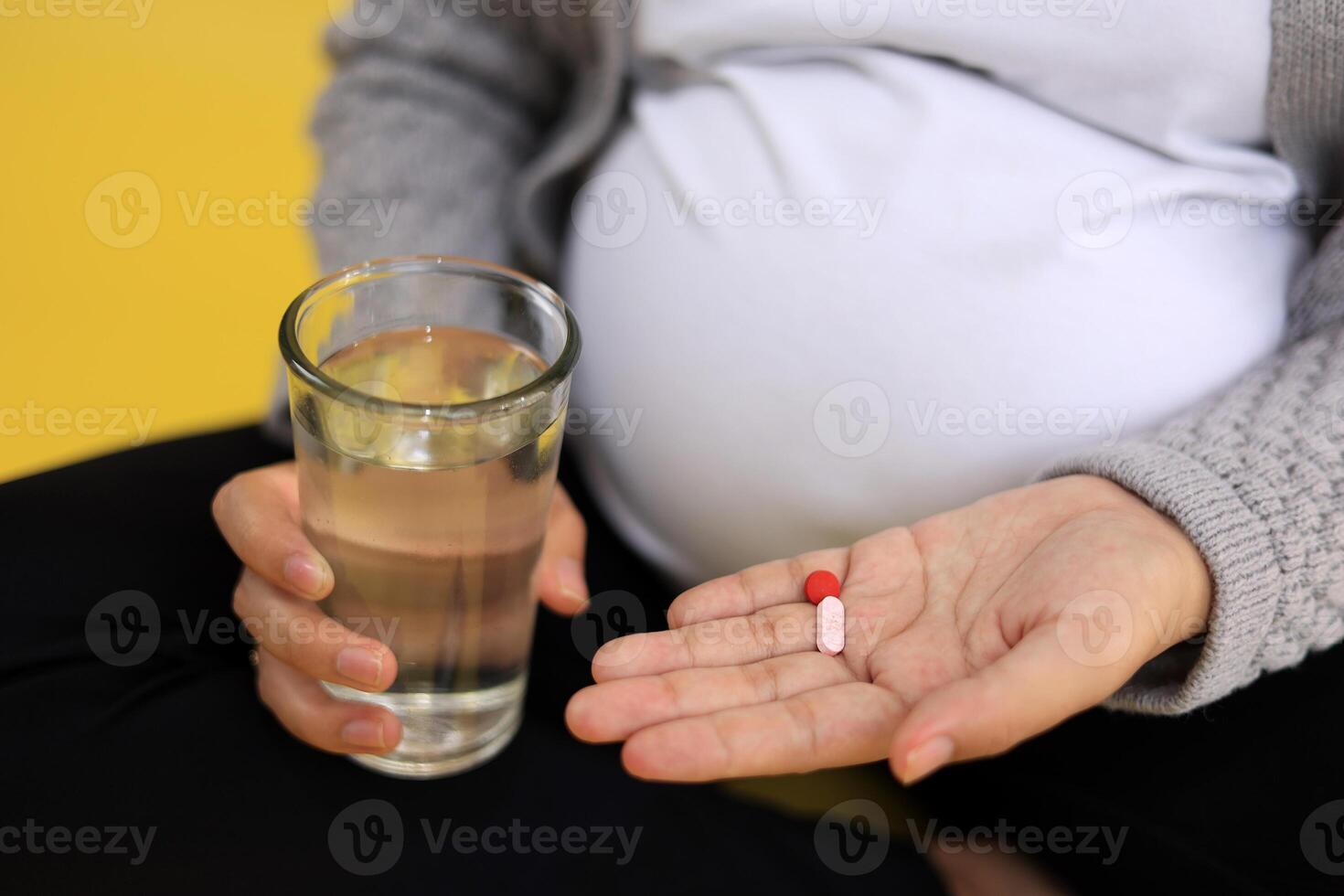Pregnant Woman with Folic Acid Pills and Glass of Water, photo