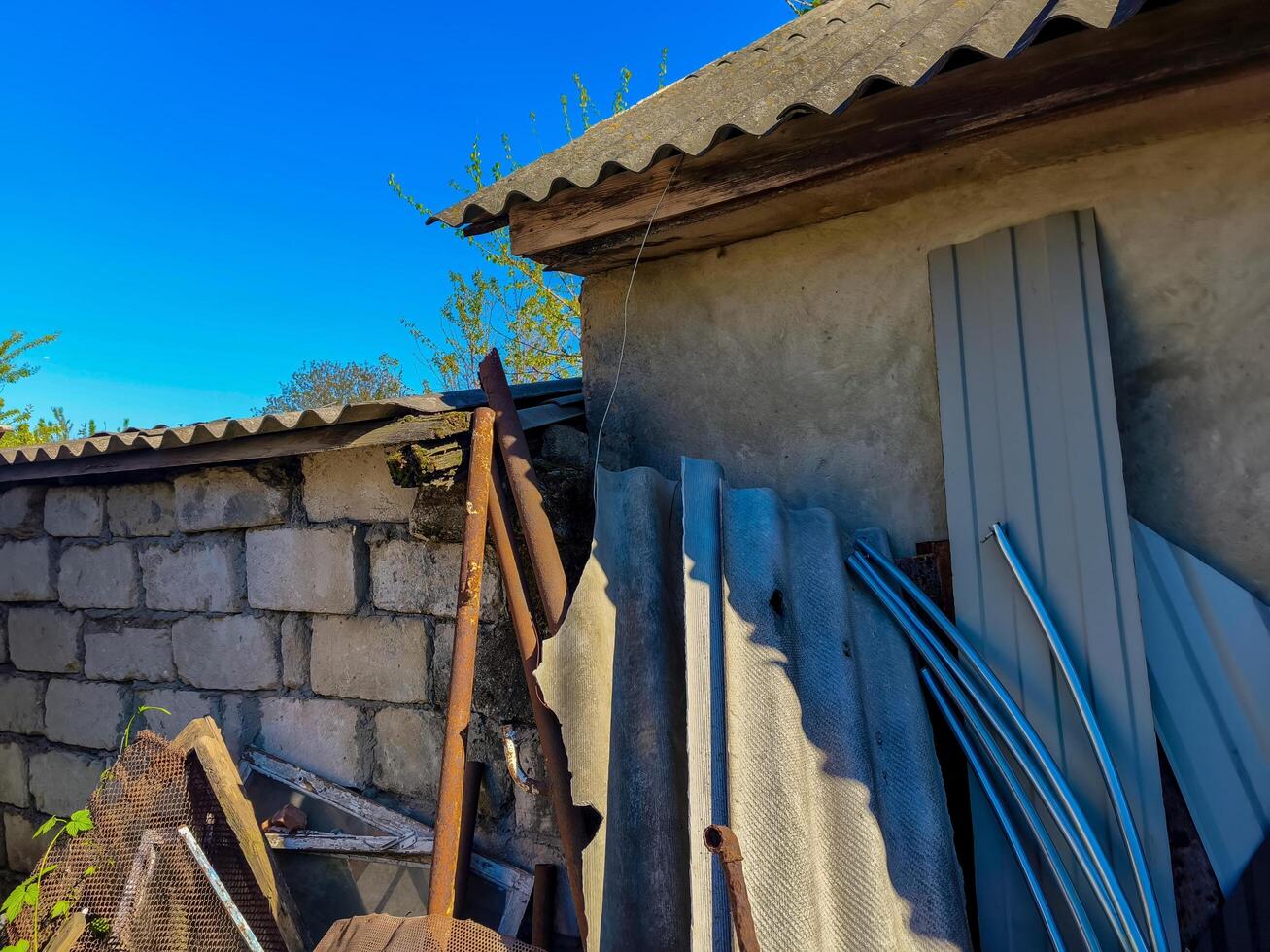 A pile of debris and broken materials are scattered around a building. Scene is one of destruction and chaos photo