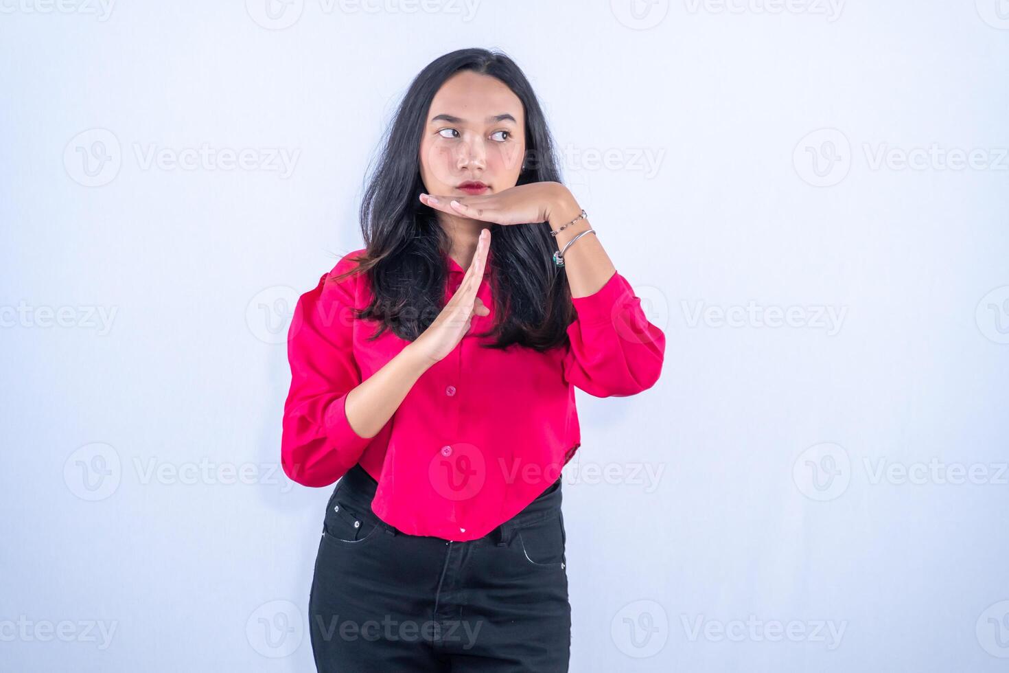 a woman in a red shirt and black pants is making a gesture photo