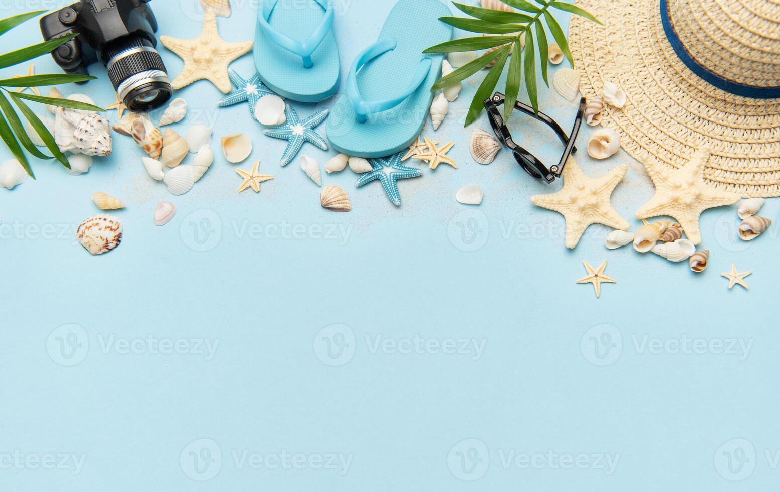 Summer accessories creating a frame on light blue background with copy space photo