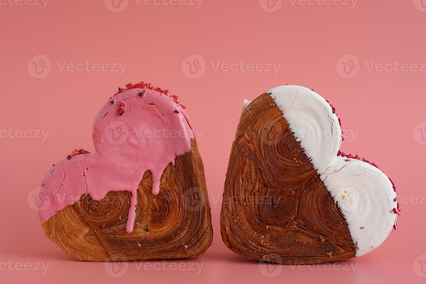 Heart shaped two couple croissants on pink background with copy space. Puff pastry new trendy sweet dessert bakery. Creamy dough experiment photo