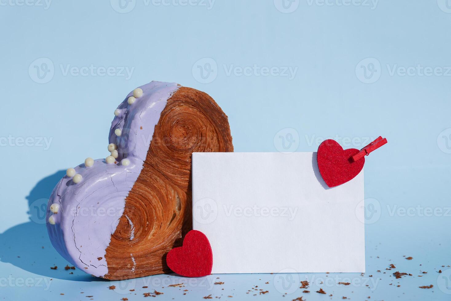 Empty paper note card template mock up Heart shaped blueberry flavor croissant on blue background with copy space. Puff pastry new trendy sweet dessert bakery. Creamy dough experiment photo