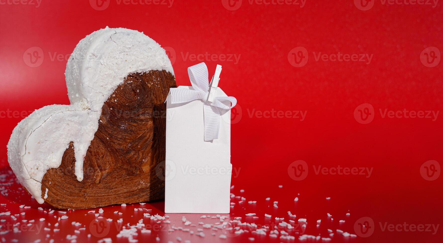 White paper note mockup template greeting holiday card Heart shaped coconut flavor croissant on red background with copy space. Puff pastry new trendy sweet dessert bakery. Creamy dough experiment photo