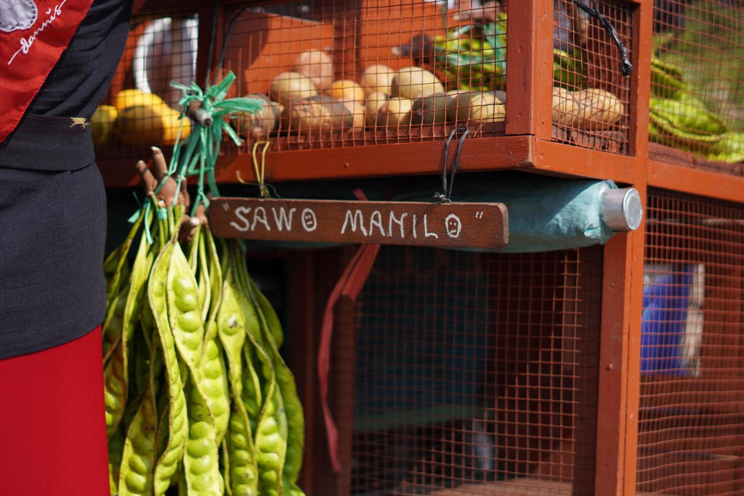 Sign of sawo manilo means sapodilla manillo in itinerant fruit traders who sell sapodilla and petai fruit use motorbikes photo