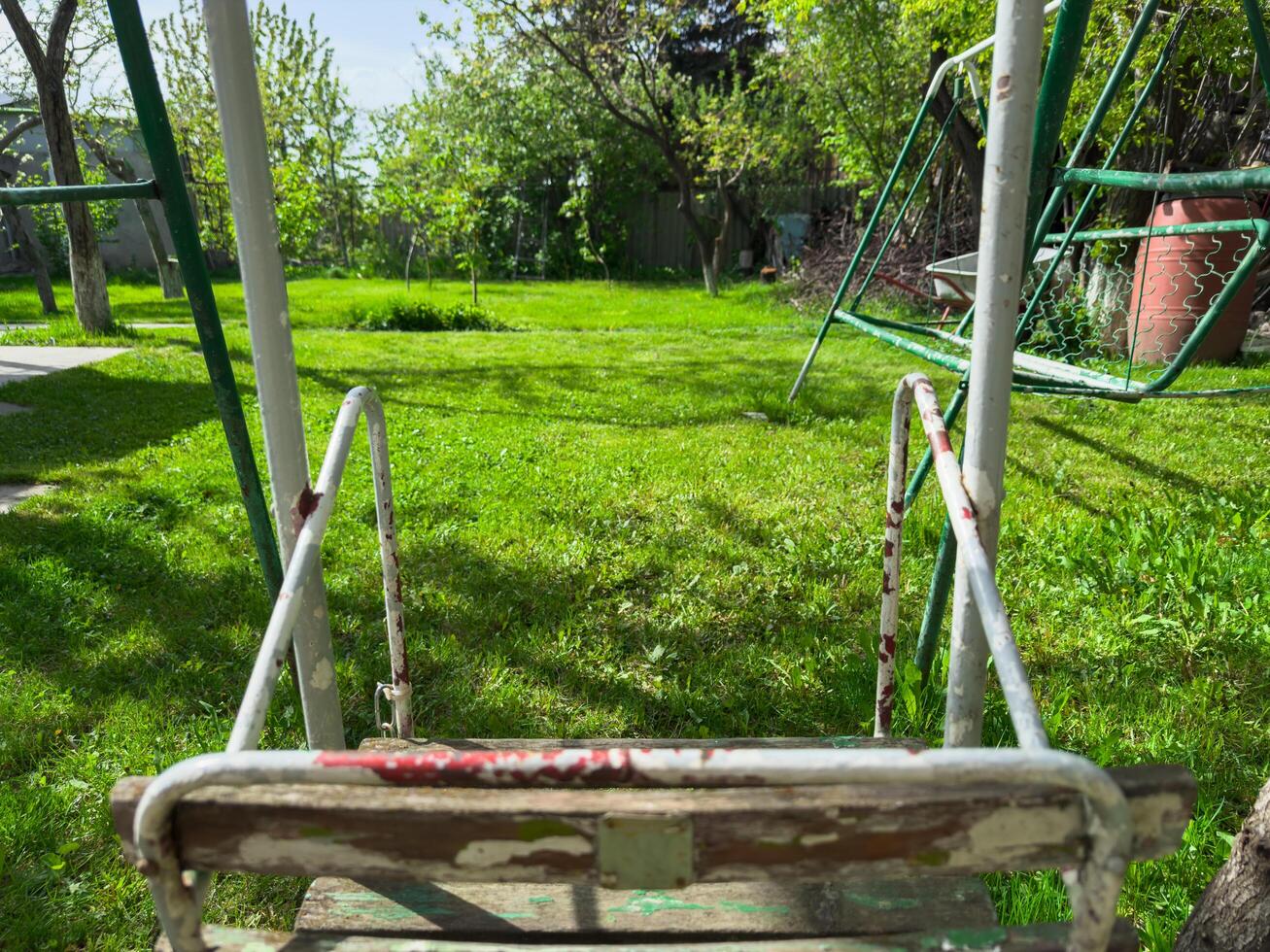 Kids empty swing in the backyard of your own house on a hot summer day, copy space photo