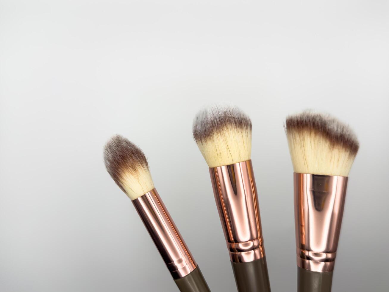 Makeup cosmetic brushes collection on white background with strong shadows background. Top view. Flat lay, knolling concept photo