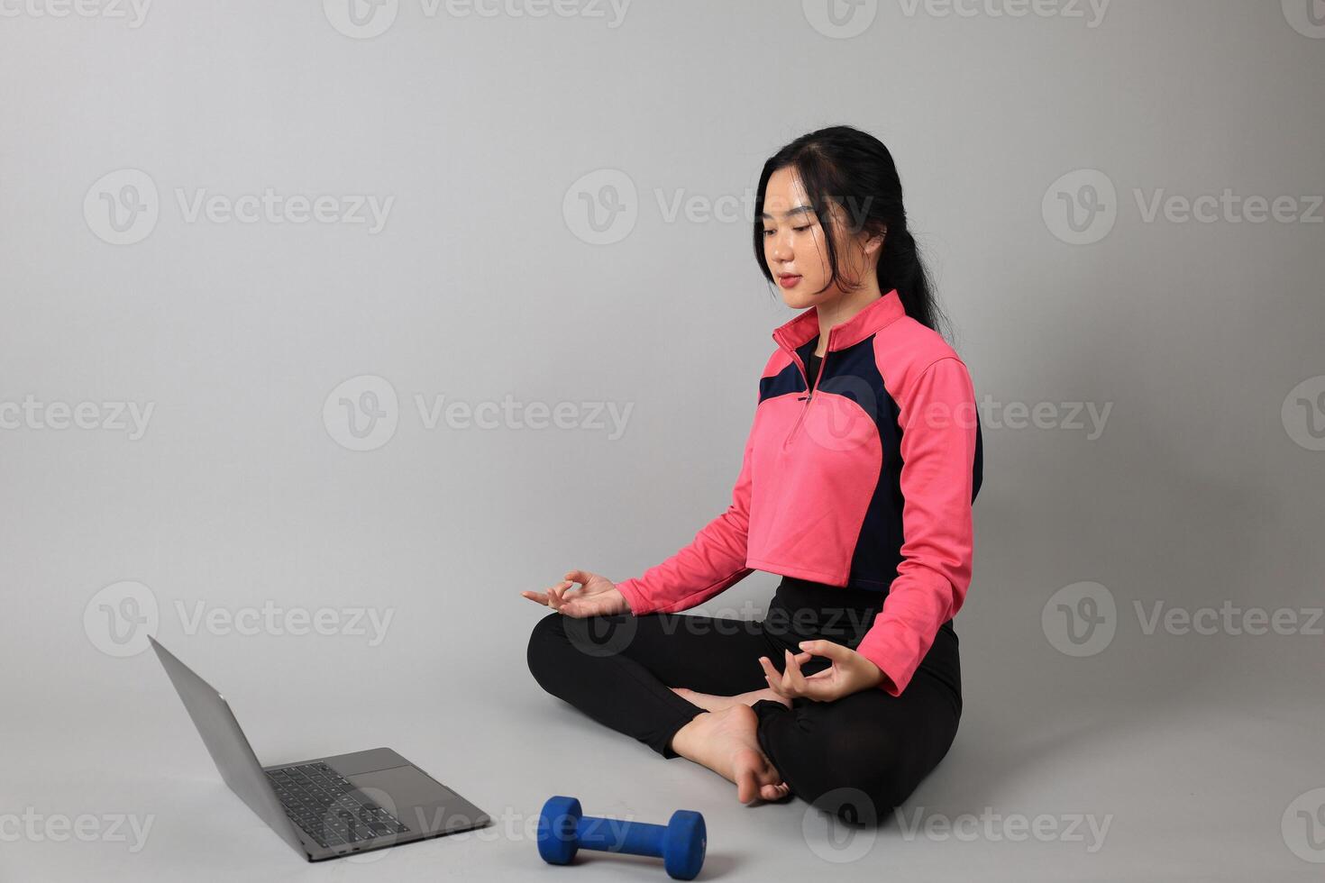 Young Woman Practicing Yoga with Online Lessons in Laptop at Home. photo