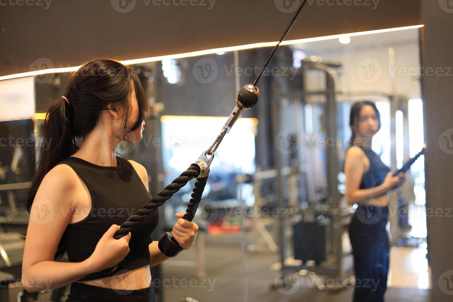 Young Woman Looking at the Mirror While Training at Gym photo