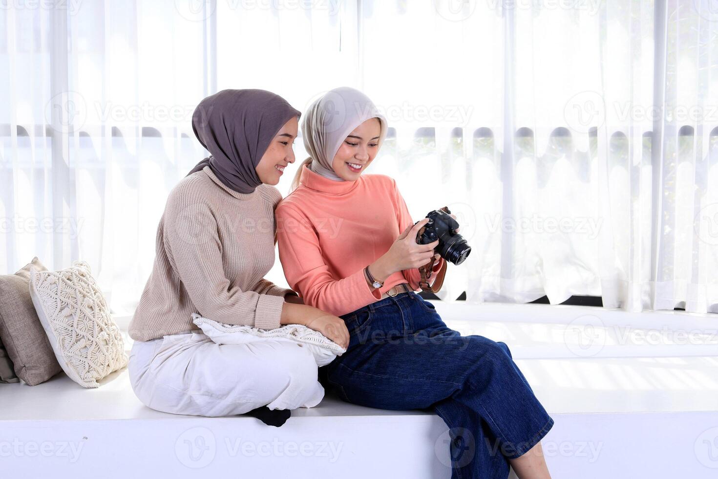 Two Young Asian Muslim Women in Beautiful Hijab Holding the Camera and Looking into it. photo