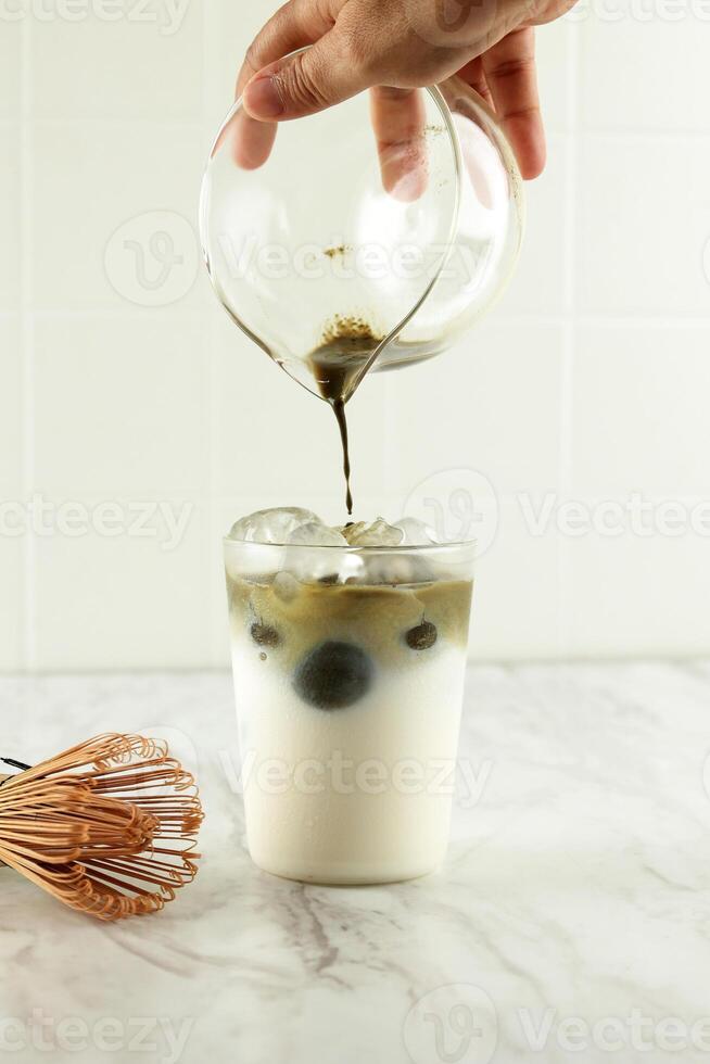 Matcha Tea is Poured in Iced Milk. photo