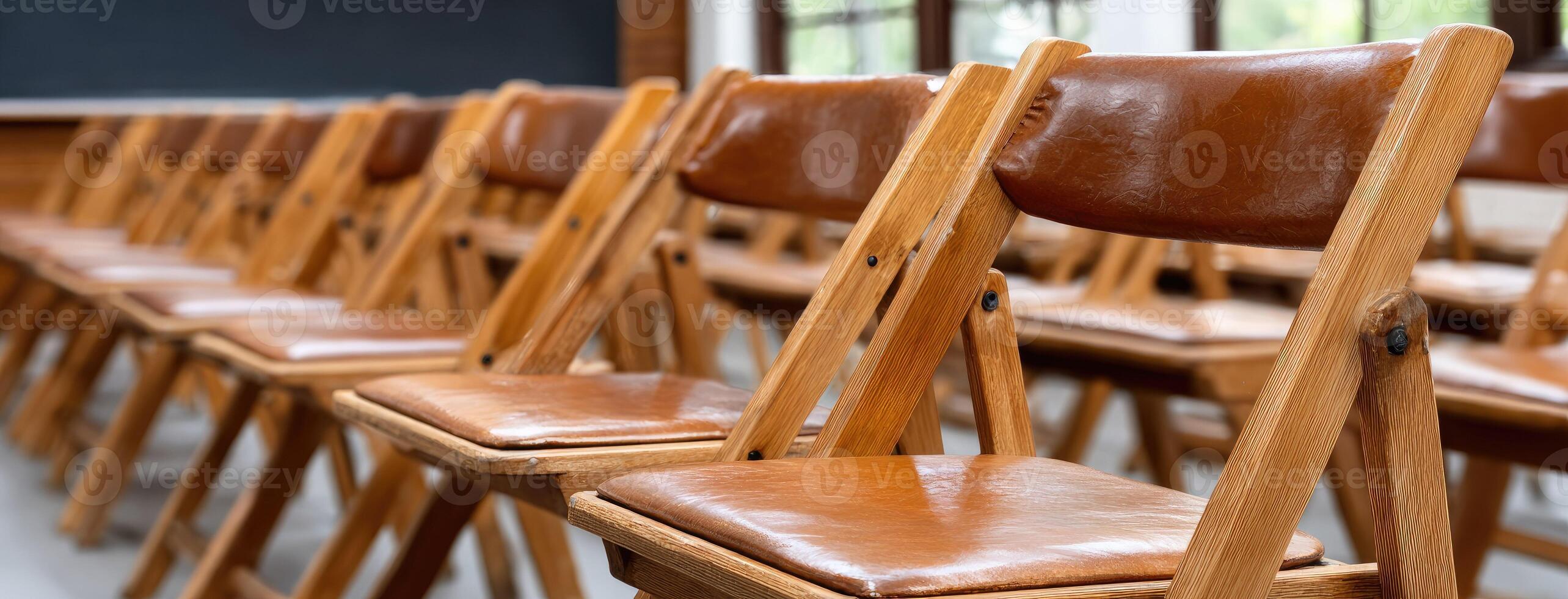 Rows of wooden chairs in a classroom photo